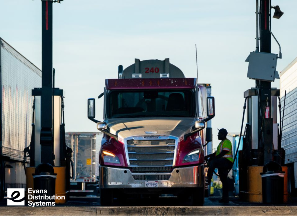 Photo of a truck driver fueling up at a gas station.